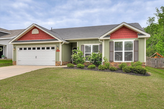 craftsman-style home featuring board and batten siding, driveway, a garage, fence, and a front lawn