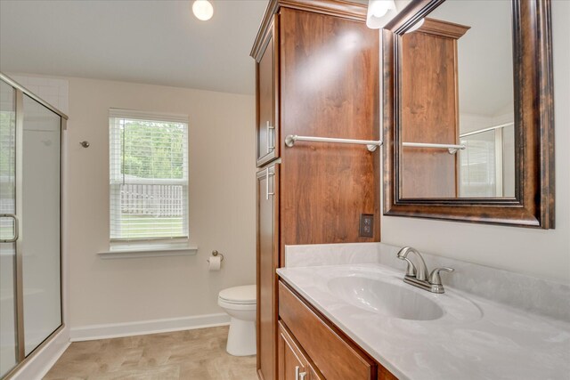 full bathroom featuring baseboards, vanity, toilet, and a shower stall