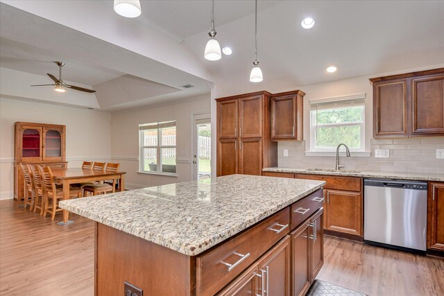 kitchen featuring a ceiling fan, a kitchen island, a sink, light wood finished floors, and dishwasher