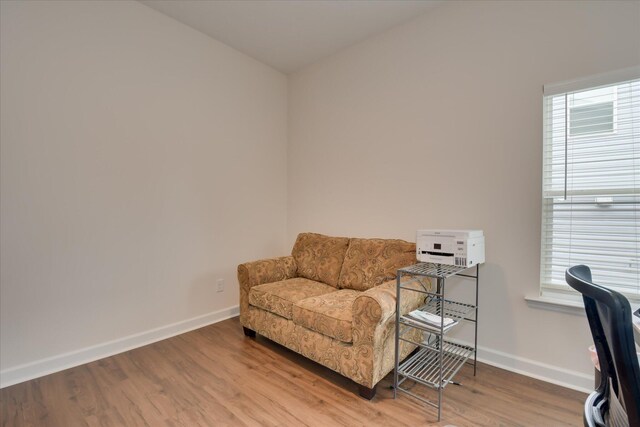living area with baseboards and wood finished floors
