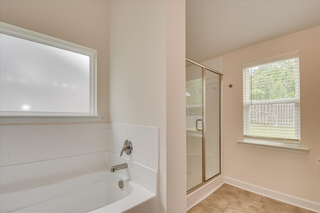 full bath with baseboards, a shower stall, and a bath