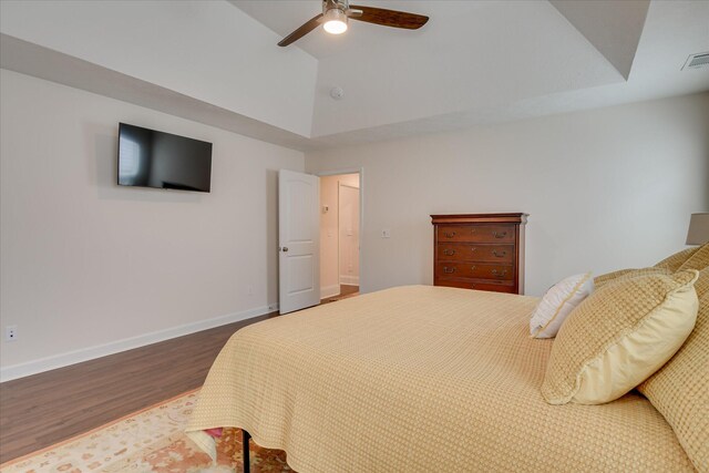 bedroom featuring a ceiling fan, baseboards, wood finished floors, lofted ceiling, and visible vents