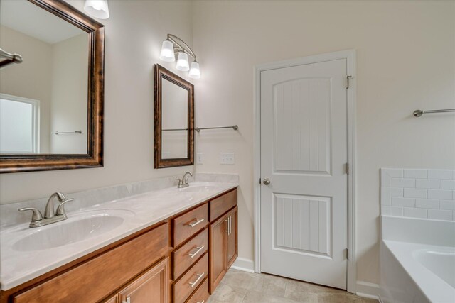 bathroom with a tub to relax in, a sink, and double vanity
