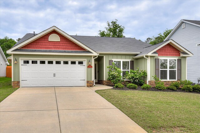 craftsman-style home with roof with shingles, an attached garage, board and batten siding, a front yard, and concrete driveway