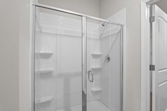 bathroom with a shower with door