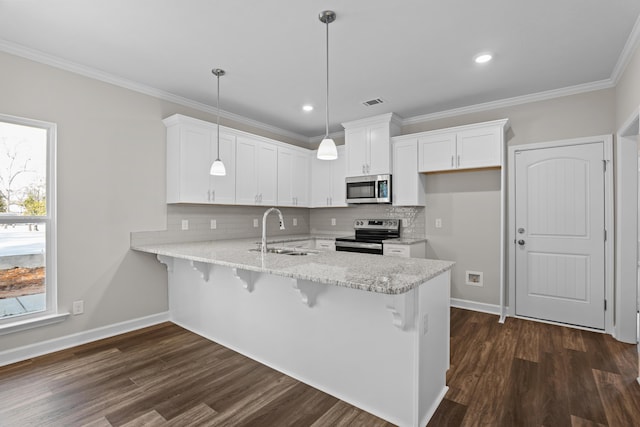 kitchen with sink, stainless steel appliances, white cabinets, decorative light fixtures, and kitchen peninsula