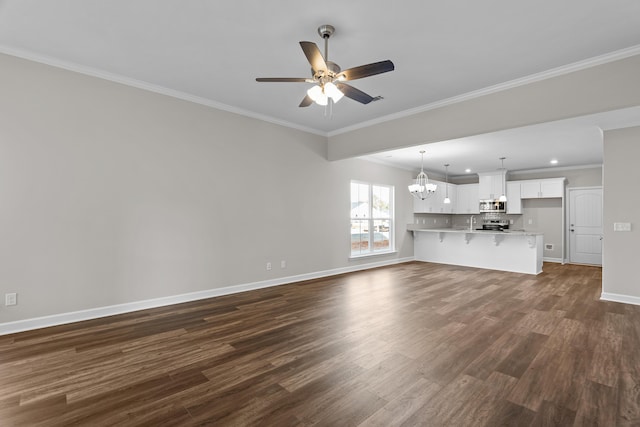 unfurnished living room featuring dark wood-type flooring, crown molding, and ceiling fan with notable chandelier