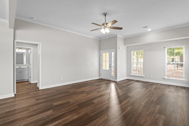 empty room with dark wood-type flooring, ornamental molding, and a wealth of natural light