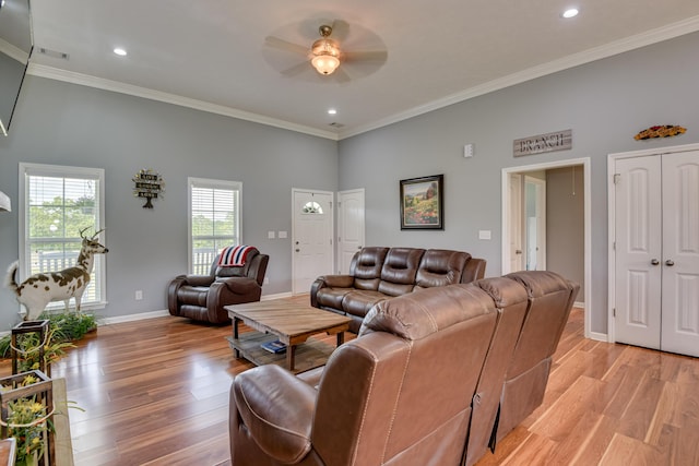 living room featuring ceiling fan, ornamental molding, and light wood-type flooring