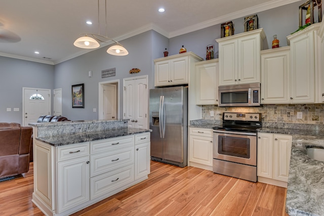 kitchen featuring crown molding, appliances with stainless steel finishes, pendant lighting, and decorative backsplash