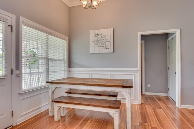 dining area featuring breakfast area, crown molding, light hardwood / wood-style floors, and a notable chandelier