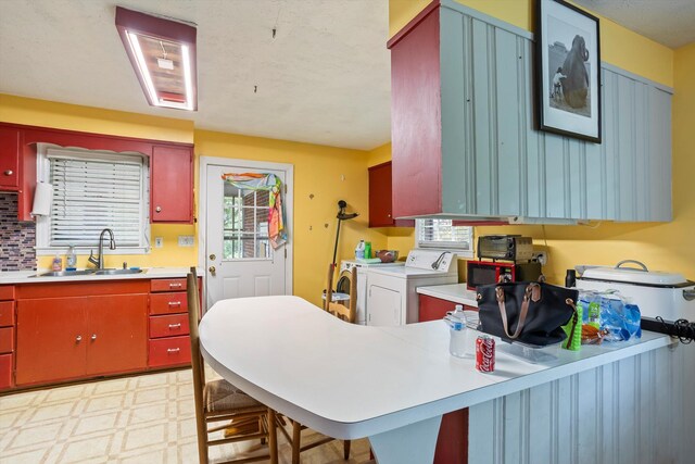 102 Briarcliff St, Belvedere, SC 29841 - kitchen with independent washer and dryer, light floors, light countertops, a peninsula, and red cabinets