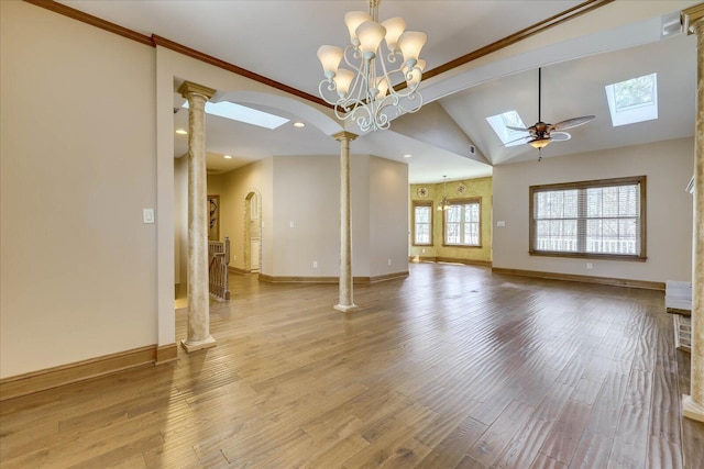 unfurnished living room with wood finished floors, baseboards, and ornate columns