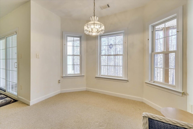 unfurnished dining area featuring visible vents, baseboards, a healthy amount of sunlight, and carpet flooring