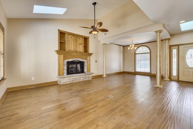 unfurnished living room with light wood-style flooring, a brick fireplace, decorative columns, and vaulted ceiling