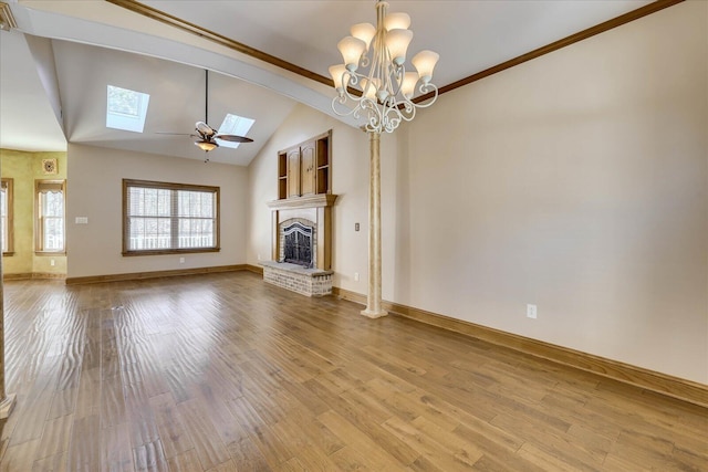 unfurnished living room with wood finished floors, baseboards, a ceiling fan, a fireplace, and lofted ceiling with skylight