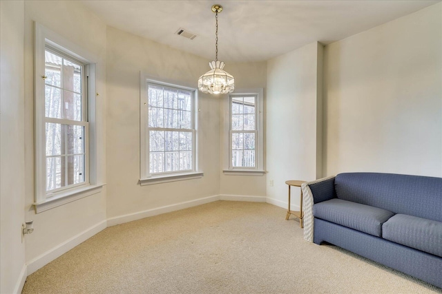 living area featuring visible vents, an inviting chandelier, baseboards, and carpet