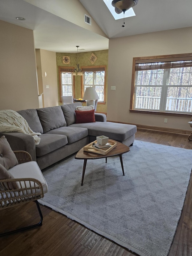 living area featuring visible vents, lofted ceiling, and wood finished floors