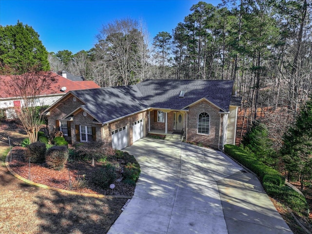 ranch-style home featuring brick siding, driveway, a shingled roof, and a garage