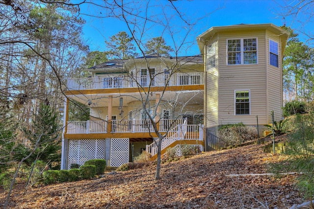 back of property featuring a balcony and stairs