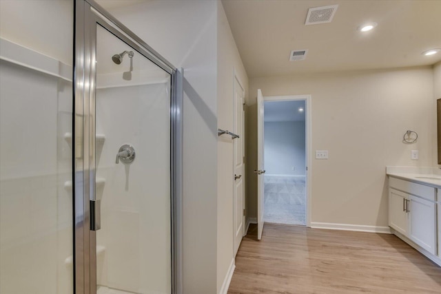 bathroom with vanity, wood-type flooring, and walk in shower