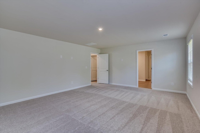 spare room featuring light colored carpet