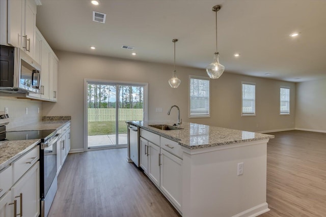 kitchen featuring white cabinetry, sink, an island with sink, and appliances with stainless steel finishes