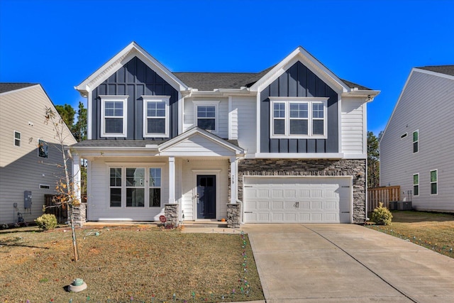 view of front of home featuring central air condition unit, a front lawn, and a garage