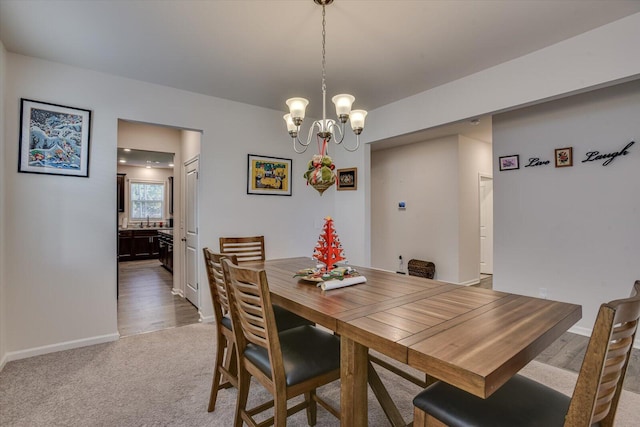 dining area featuring sink, carpet, and an inviting chandelier