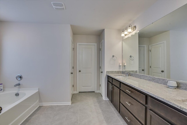 bathroom featuring tile patterned flooring, vanity, and a washtub