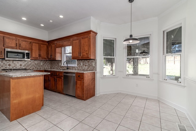 kitchen with a sink, tasteful backsplash, brown cabinets, light stone counters, and light tile patterned floors