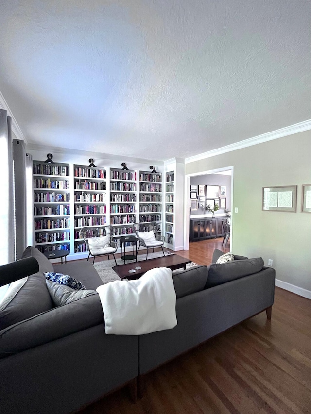 living area with baseboards, crown molding, a textured ceiling, and wood finished floors