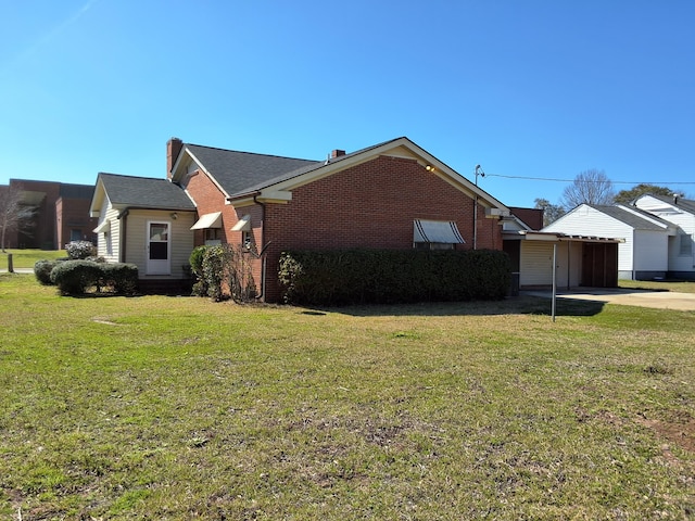 view of side of home featuring brick siding and a lawn