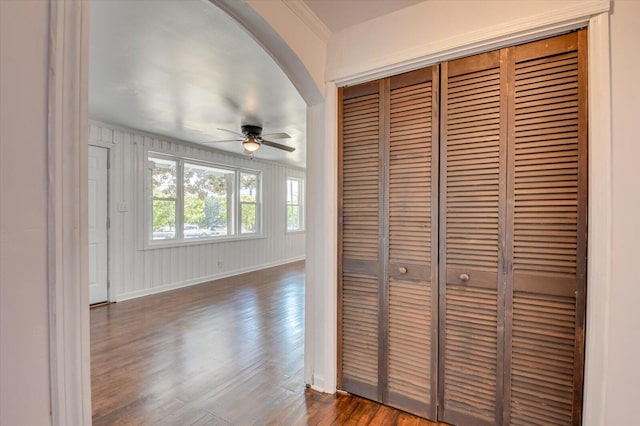 hallway with crown molding and dark wood-type flooring