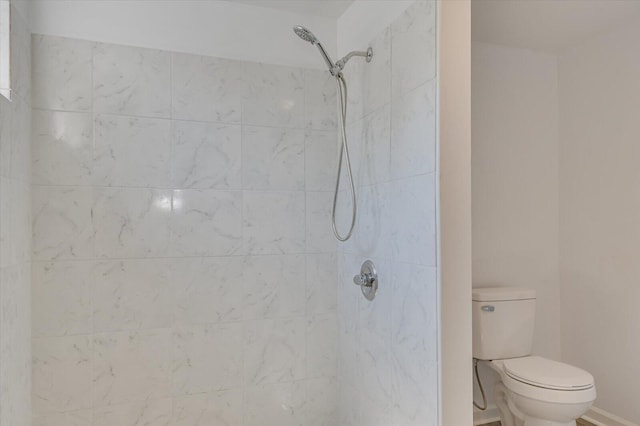 bathroom with tiled shower and toilet