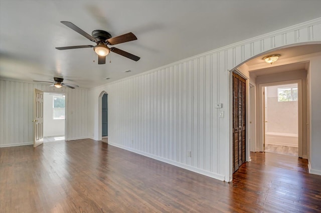 unfurnished room featuring ceiling fan, dark hardwood / wood-style flooring, and ornamental molding