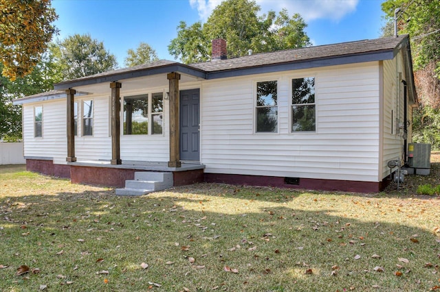 view of front of house featuring central AC and a front lawn