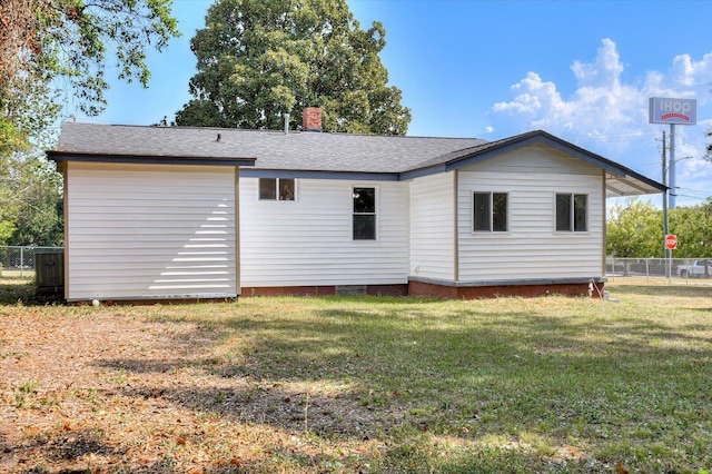 rear view of property featuring a yard and central AC