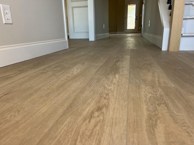 unfurnished living room featuring baseboards and wood finished floors