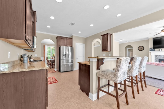 532 Bunchgrass St, Evans, GA 30809 - kitchen featuring stainless steel refrigerator with ice dispenser, a peninsula, arched walkways, open floor plan, and a kitchen bar