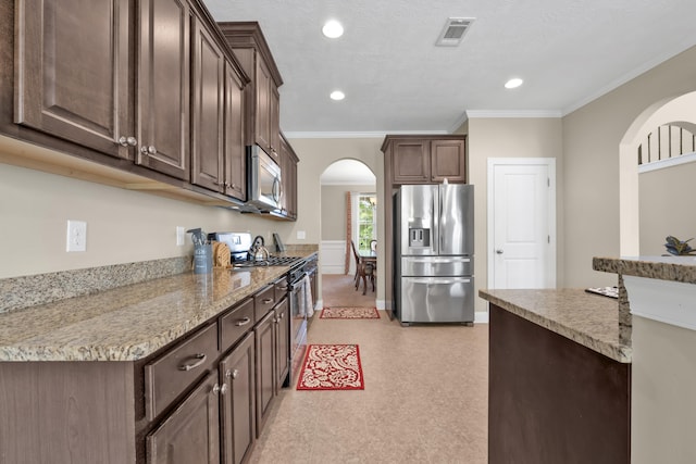 532 Bunchgrass St, Evans, GA 30809 - kitchen featuring appliances with stainless steel finishes, arched walkways, dark brown cabinets, recessed lighting, and ornamental molding