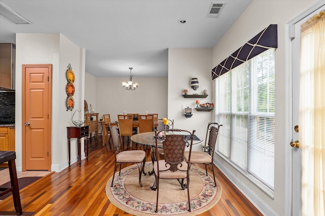 dining room with visible vents, light wood-type flooring, a chandelier, and baseboards