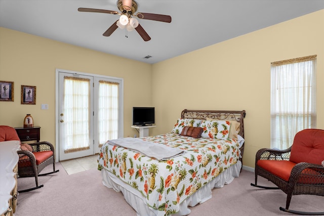 bedroom with carpet floors, tile patterned flooring, access to exterior, ceiling fan, and visible vents