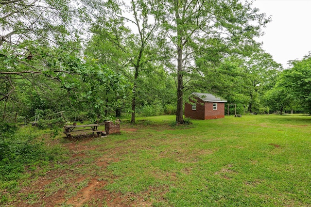 view of yard featuring an outdoor structure and a wooded view