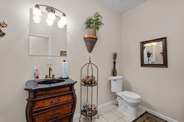 bathroom featuring baseboards, toilet, tile patterned flooring, and vanity