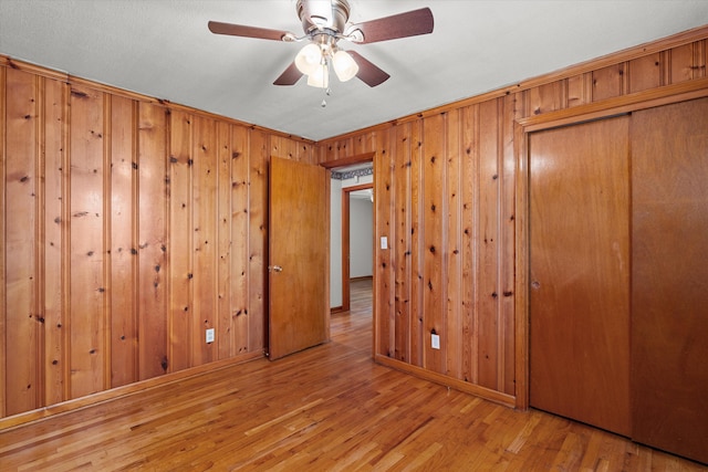 2211 Woodland Ave, Augusta, GA 30904 - unfurnished bedroom with wood finished floors, a closet, wood walls, and a ceiling fan