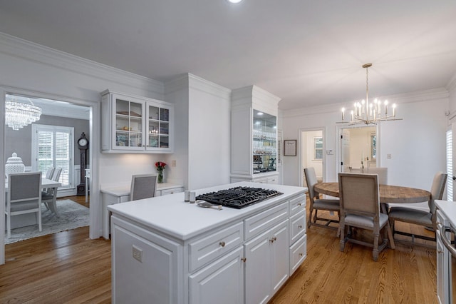 3665 Bay Point Ct, Martinez, GA 30907 - kitchen with a chandelier, gas stovetop, light wood-type flooring, white cabinets, and crown molding