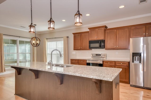 kitchen featuring brown cabinets, stainless steel appliances, tasteful backsplash, ornamental molding, and a sink