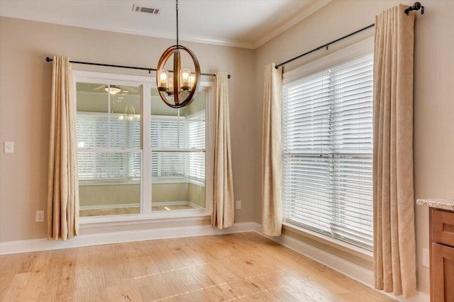 unfurnished dining area with ornamental molding, a healthy amount of sunlight, visible vents, and baseboards