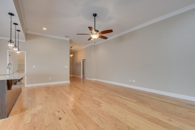 unfurnished living room with ceiling fan, light wood-type flooring, baseboards, and crown molding